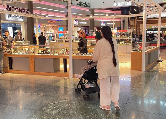 Una mamma col figlio in passeggino nell'aeroporto di Istanbul